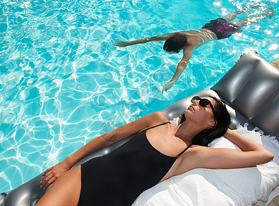 泳池晒日光浴的女子背景图片