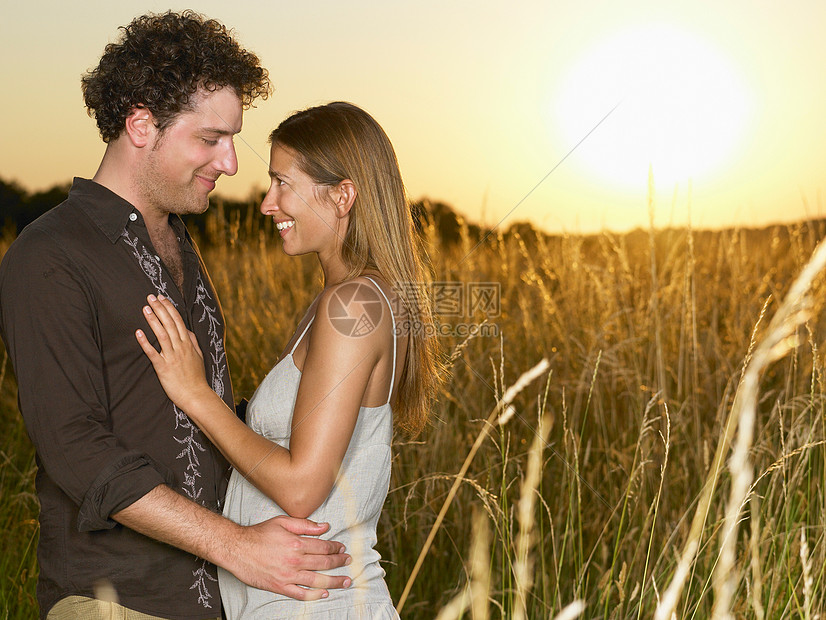 日落时分在田野里的情侣图片