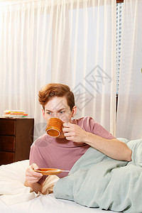 在床上喝咖啡的男人图片