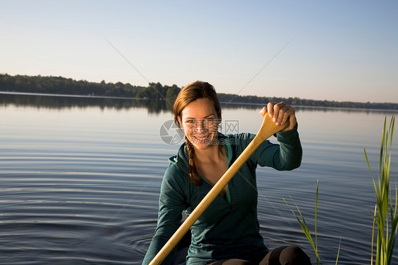 妇女在晨光中划独木舟图片