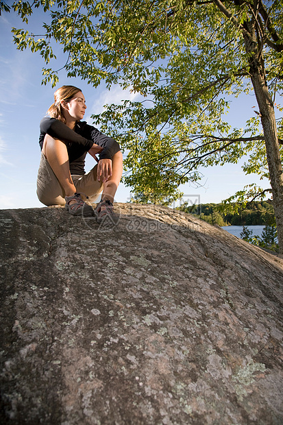 坐在岩石上的女人图片