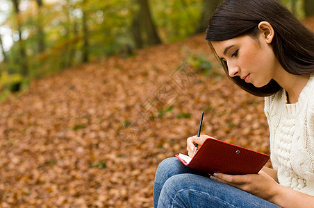 在树林里看书的女孩图片