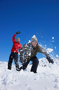 在雪地里玩耍的年轻夫妇图片