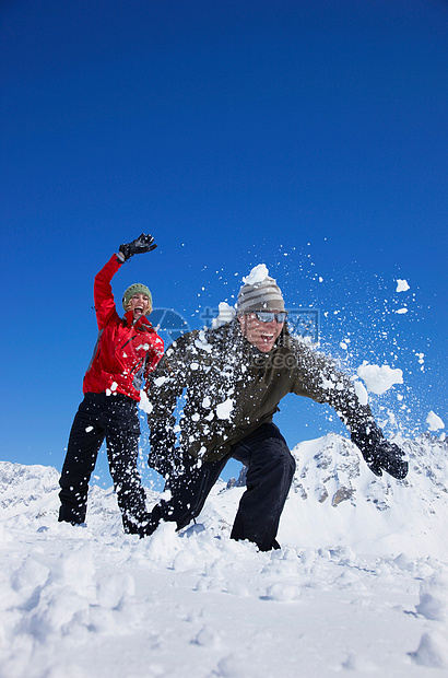 在雪地里玩耍的年轻夫妇图片