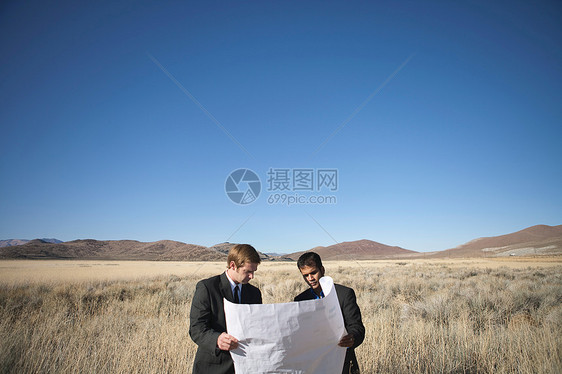 两名男子在实地检查蓝图图片