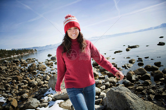 在雪湖附近岩石上行走的女人图片