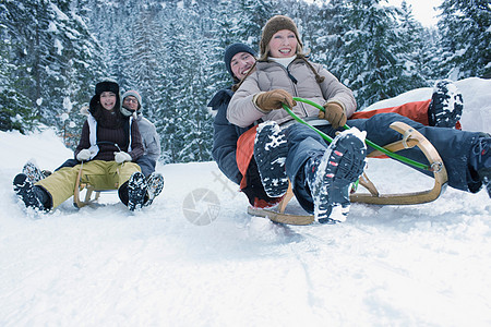 青少年在雪地里坐雪橇图片