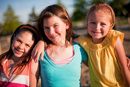 3个微笑的年轻女孩拥抱图片