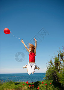 小女孩牵着红气球跳图片