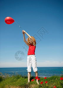小女孩牵着红气球跳图片