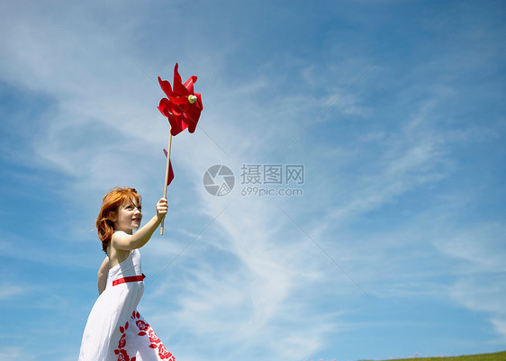 和风车一起跑的年轻女孩图片