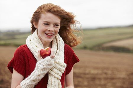 少女在田里吃苹果图片