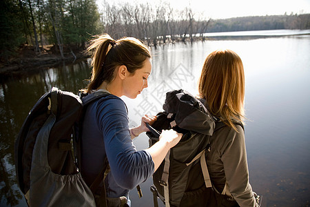 两个女人在湖边徒步旅行图片