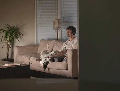 人和狗在沙发上看电视图片