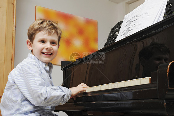 在客厅弹钢琴的男孩图片