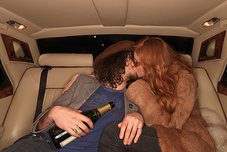 一对情侣在豪华轿车后座接吻图片