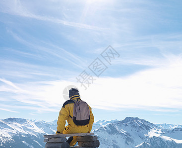 男人坐在山顶长椅上图片