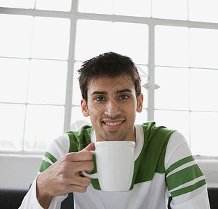 一个拿着杯子的男人的肖像图片