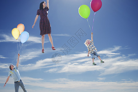 一家三口抓着气球漂浮图片