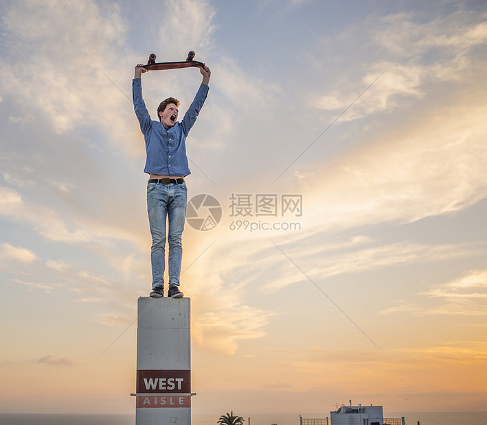 ‘~年轻人举着滑板站在柱子上的肖像  ~’ 的图片