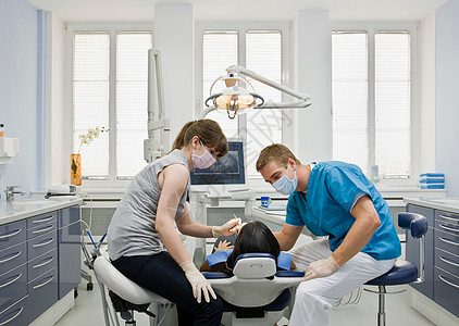 带病人和助手的牙医图片