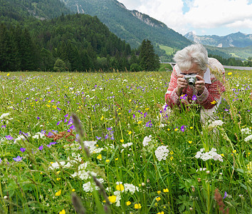 女人在花丛里拍照图片