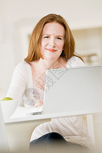 微笑的女人用笔记本电脑图片
