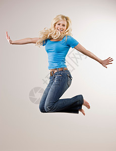 微笑的女孩在空中跳跃图片