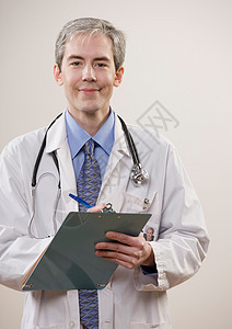 微笑的医生在写字板上写字图片