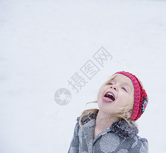 蹒跚学步的孩子伸出舌头来尝雪的味道图片