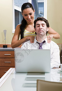 女人帮助男人在电脑前放松图片