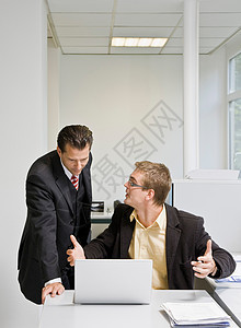 老板和同事一起看笔记本电脑图片