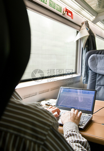 火车上用笔记本电脑打字的男人图片