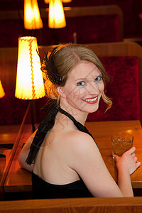 微笑的女人在餐馆喝酒图片