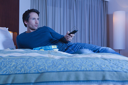 商务旅行酒店床上的男人看电视背景