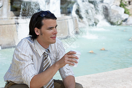 坐在喷泉边的商人图片