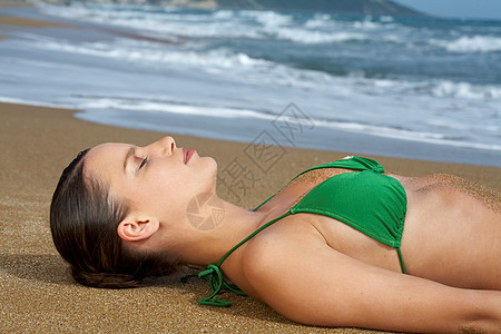 海滩上穿着比基尼的年轻女子图片