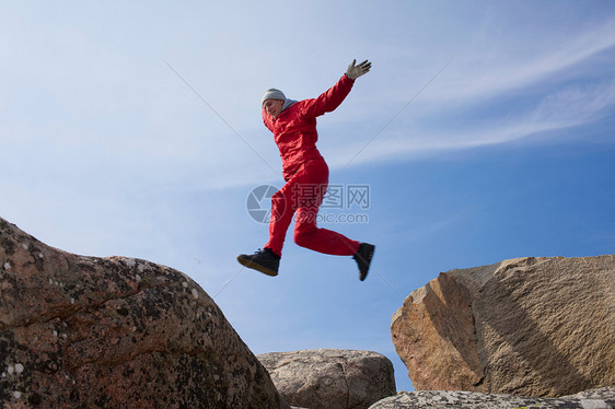在巨石之间跳跃的人图片