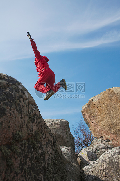 在巨石之间跳跃的人图片