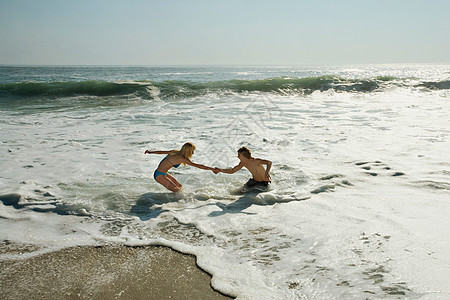 夫妻在冲浪中互相帮助图片