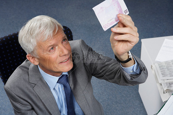 商人检查一张500欧元的钞票图片