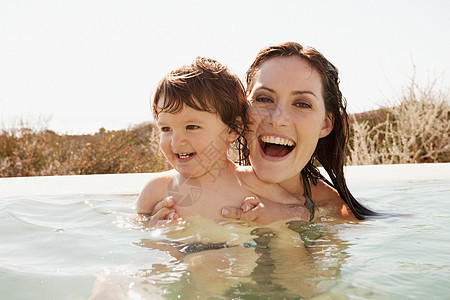 妈妈和婴儿在游泳池里游泳图片