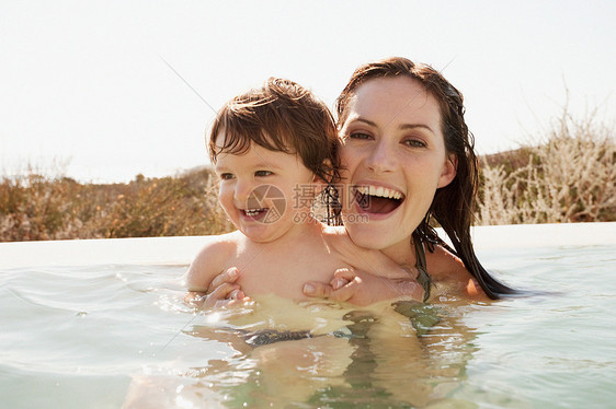 妈妈和婴儿在游泳池里游泳图片