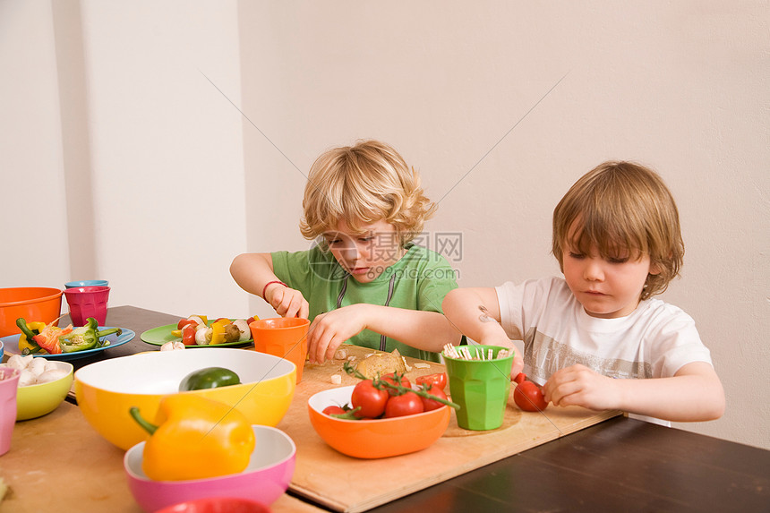 两个男孩切蔬菜图片