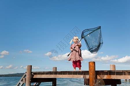 在湖中用网捕鱼的女孩图片