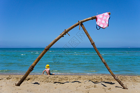 海滩浮木上悬挂的泳衣图片