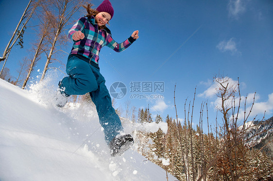 女孩在雪地里跳跃图片