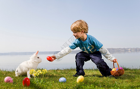 孩子带着小兔子找复活节彩蛋图片