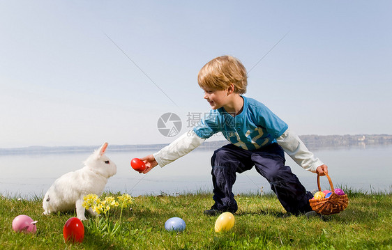 孩子带着小兔子找复活节彩蛋图片