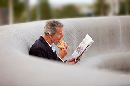 在户外吃早餐的商务男士图片